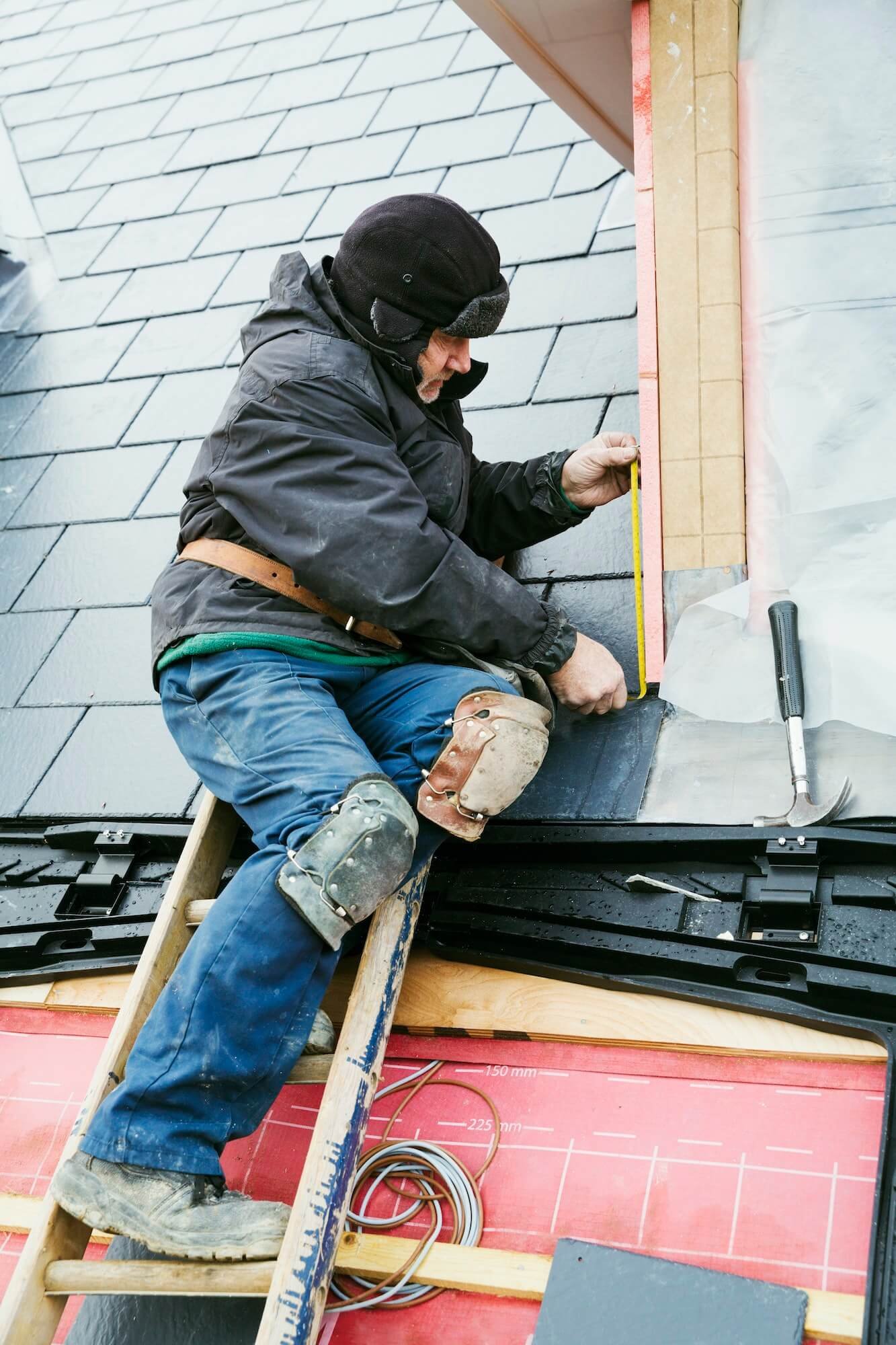 a-man-at-the-top-of-a-ladder-on-a-house-roof-fixing-tiles-on-a-dormer-roof-1-1.jpg